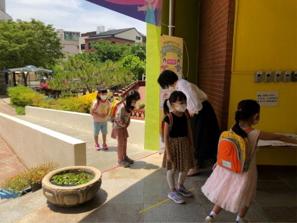 용황유치원에서 등원하는 원아들이 교사에게 '배꼽인사'를 하고 있다.