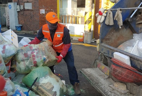 사진은 환경미화원이 청소차에 생활쓰레기를 싣는 모습.